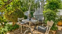 Parker Cottage's private garden oasis, showcasing elegant outdoor furniture set amongst vibrant greenery, providing a peaceful retreat for guests.